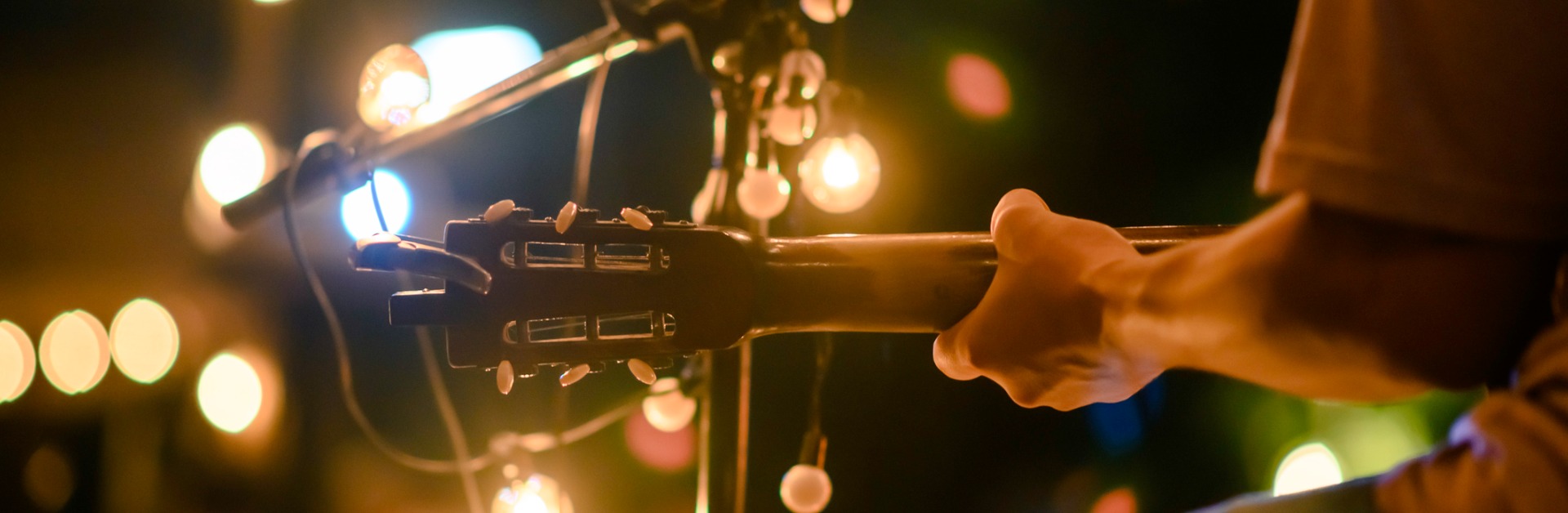 rear view of the man sitting play acoustic guitar on the outdoor a picture id1178258274